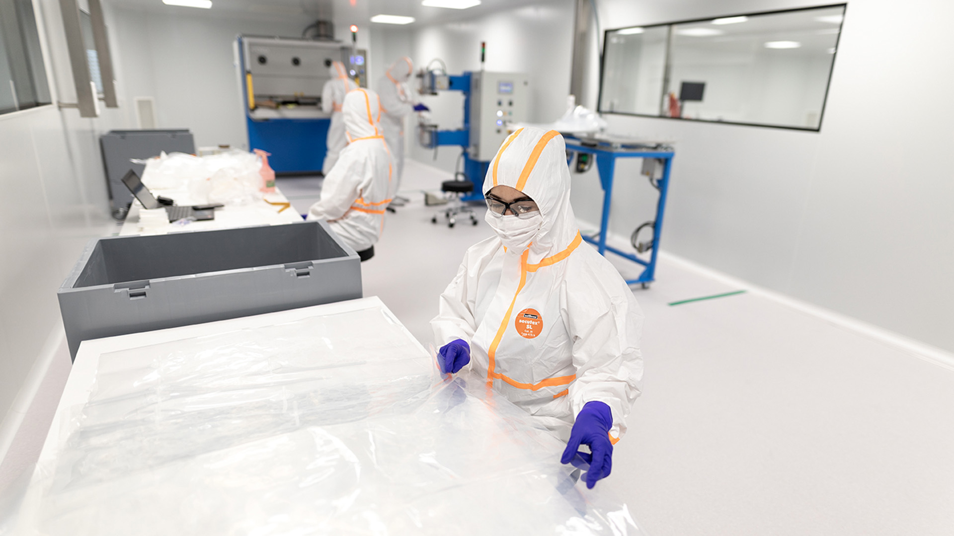 People working in an ISO7 cleanroom making single use systems.