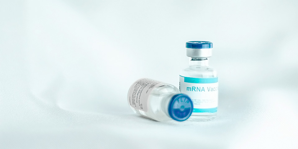 two mrna vaccines on a white background, with a blue and white label